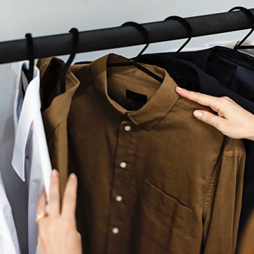 A customer looking at shirts on a rack in a fashion store