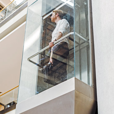 Business man in a glass elevator