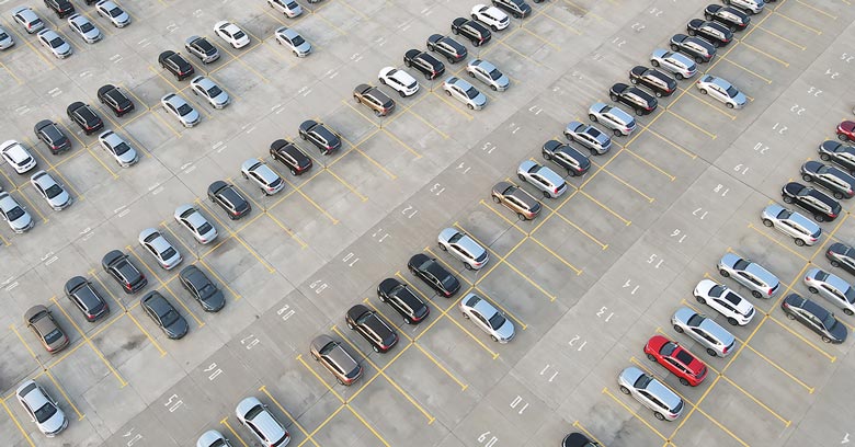 New cars parked outside a factory