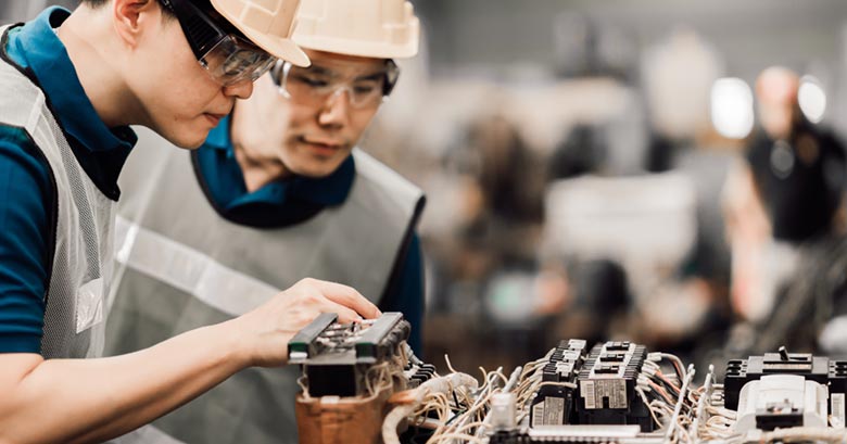 Workers on a technology processing line