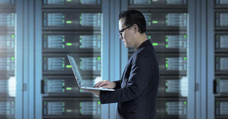 Engineer using a laptop computer in a server room